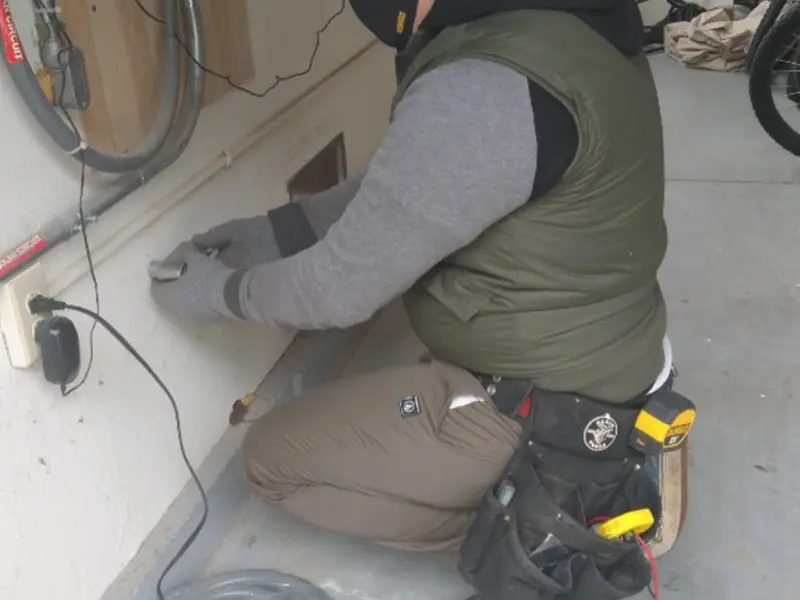 Electrician performing outlet wiring in a Ranlo garage